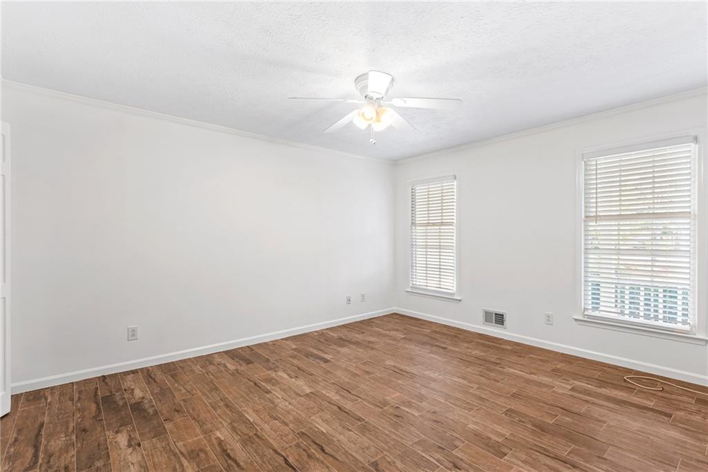 5184 West Price Road Suwanee, GA 30024 - Photo 10 of 25 an empty room with wooden floor fan and windows