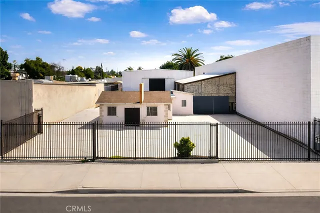 a view of a house with a wooden fence
