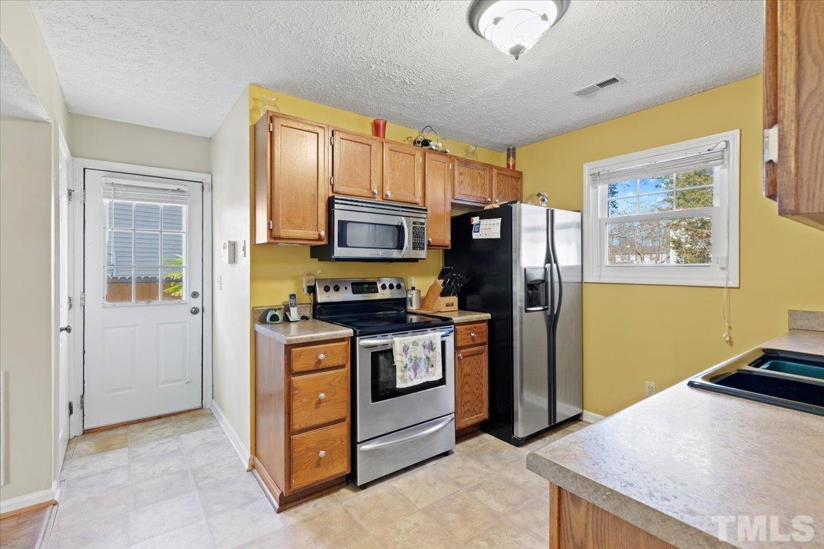 8224 Wynewood Court Raleigh, NC 27616 - Photo 12 of 29 a kitchen with stainless steel appliances granite countertop a refrigerator stove and sink