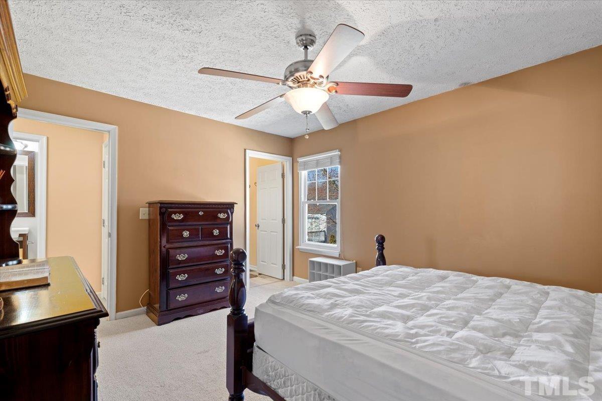 8224 Wynewood Court Raleigh, NC 27616 - Photo 17 of 29 a bedroom with a bed and a chandelier