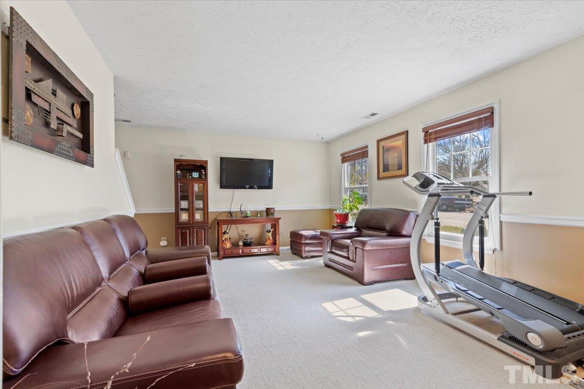 8224 Wynewood Court Raleigh, NC 27616 - Photo 5 of 29 a living room with furniture and a flat screen tv