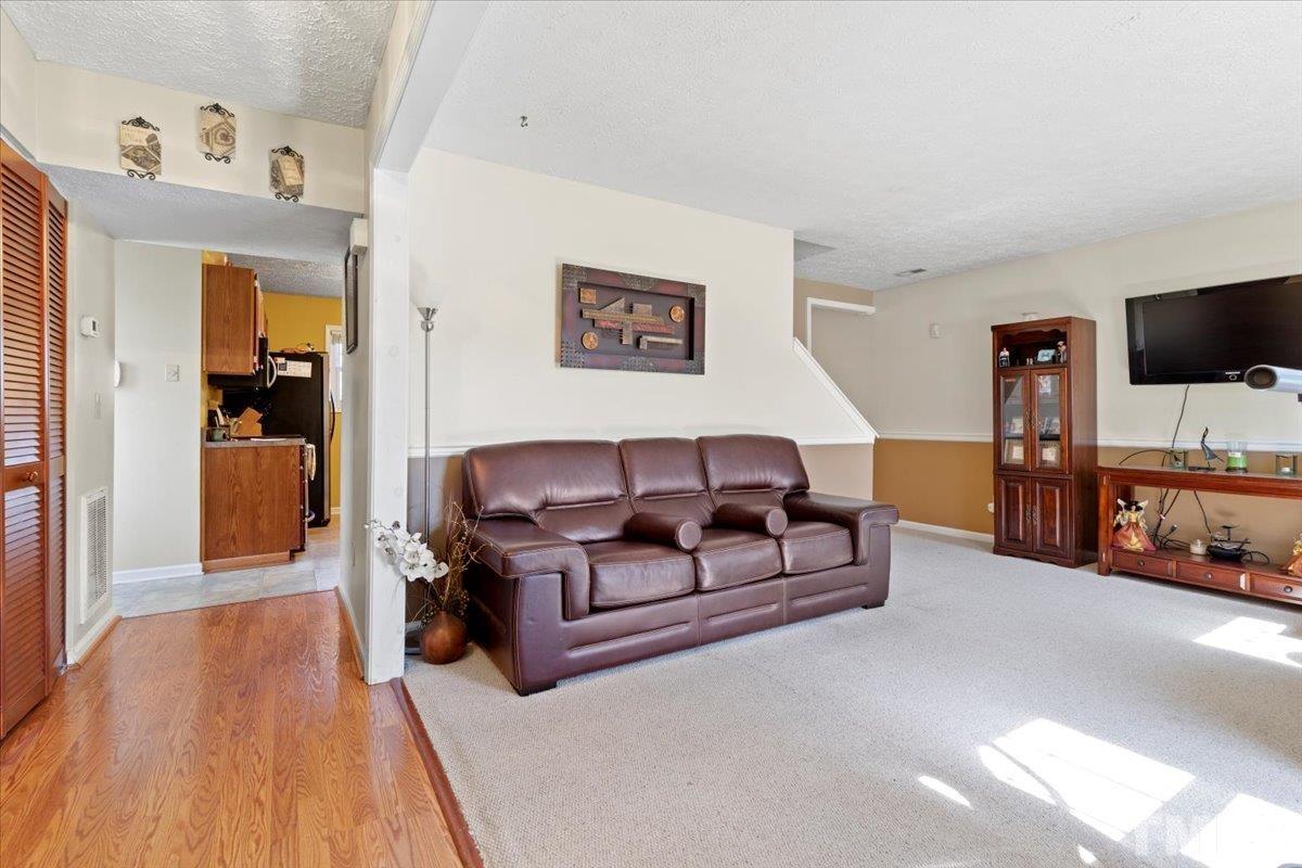 8224 Wynewood Court Raleigh, NC 27616 - Photo 8 of 29 a living room with furniture and a flat screen tv
