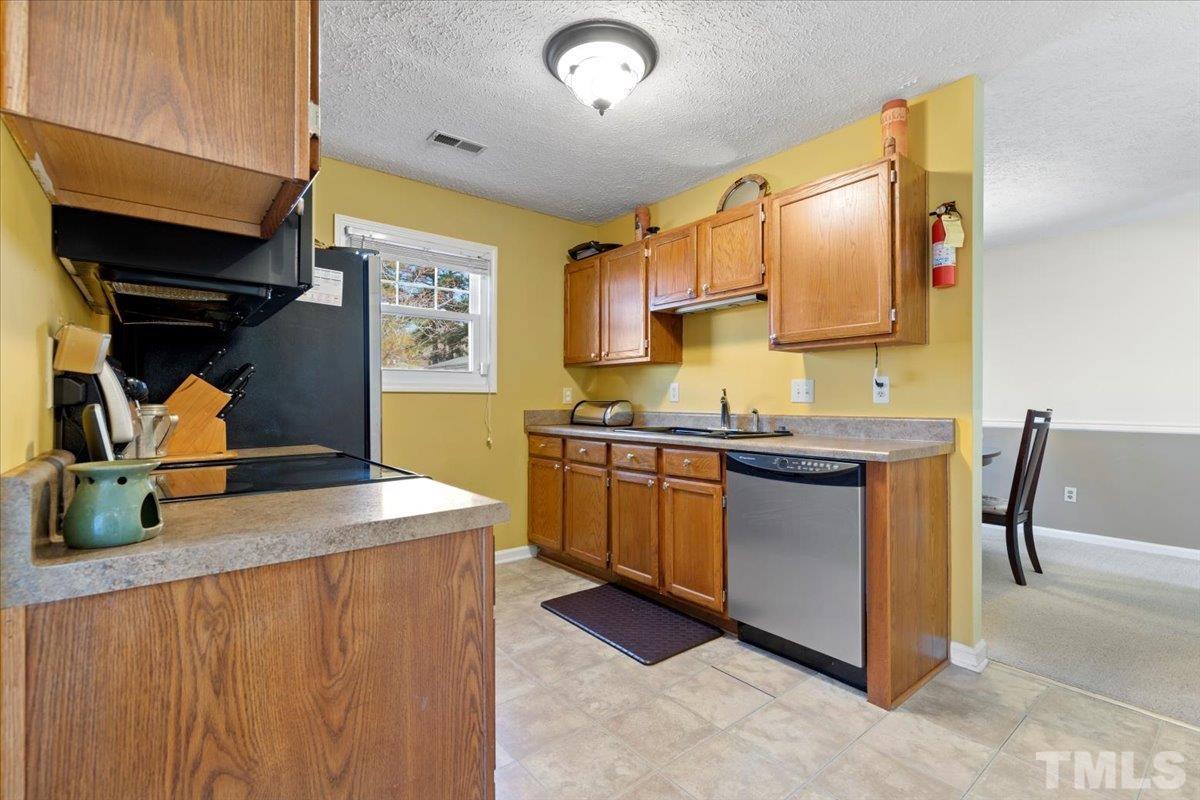 8224 Wynewood Court Raleigh, NC 27616 - Photo 10 of 29 a kitchen with sink a stove and chairs