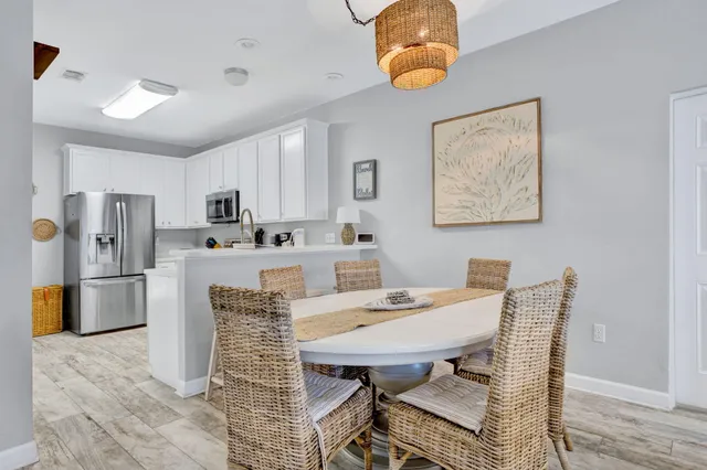 a view of kitchen with refrigerator a microwave and dining table