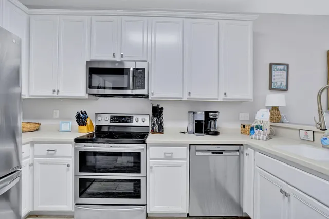 a kitchen with white cabinets and appliances