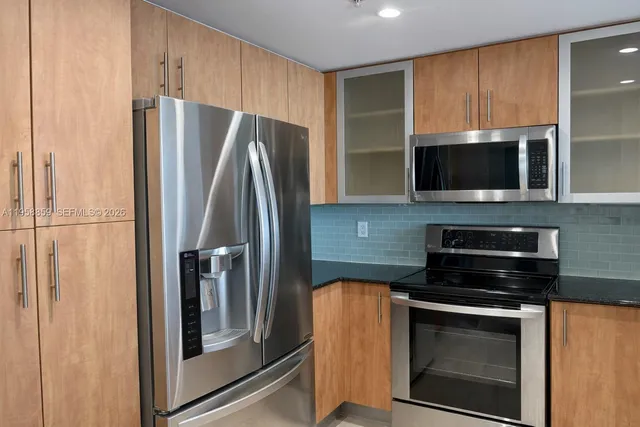 a view of an empty room with wooden floor and windows
