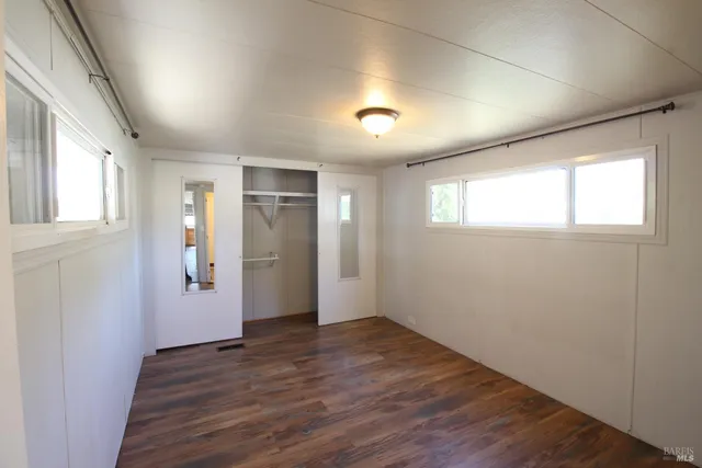 an empty room with wooden floor and a window