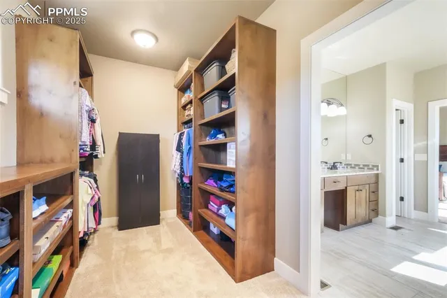 a view of walk in closet with clothes and shoes