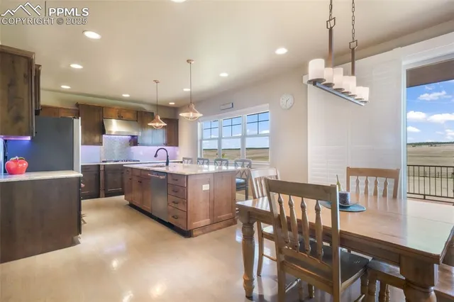 a kitchen with kitchen island stainless steel appliances a dining table and chairs