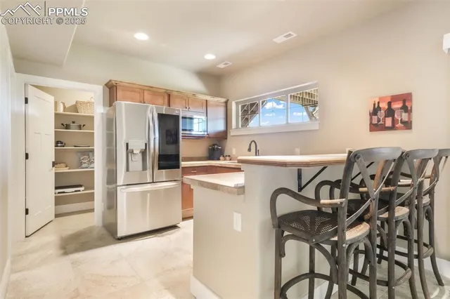 a kitchen with stainless steel appliances a refrigerator and a stove top oven
