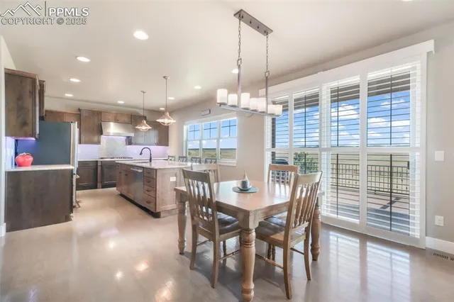 a view of a dining room and livingroom with furniture wooden floor a chandelier