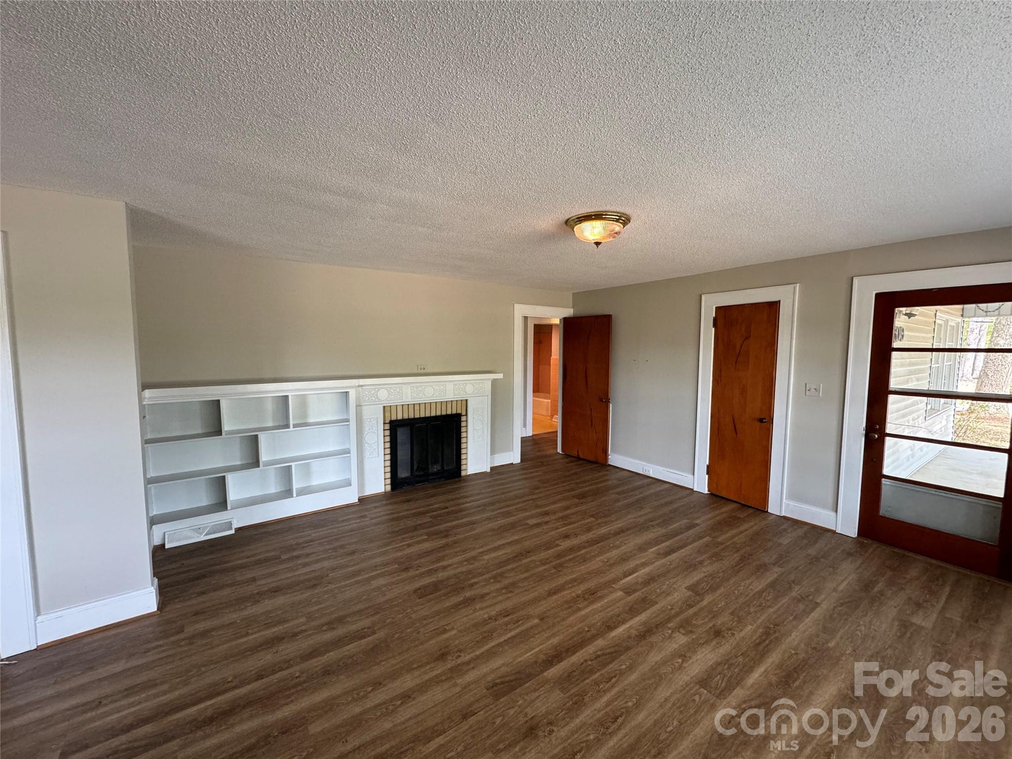 509 East Main Street Locust, NC 28097 - Photo 6 of 40 a view of empty room with wooden floor and fireplace