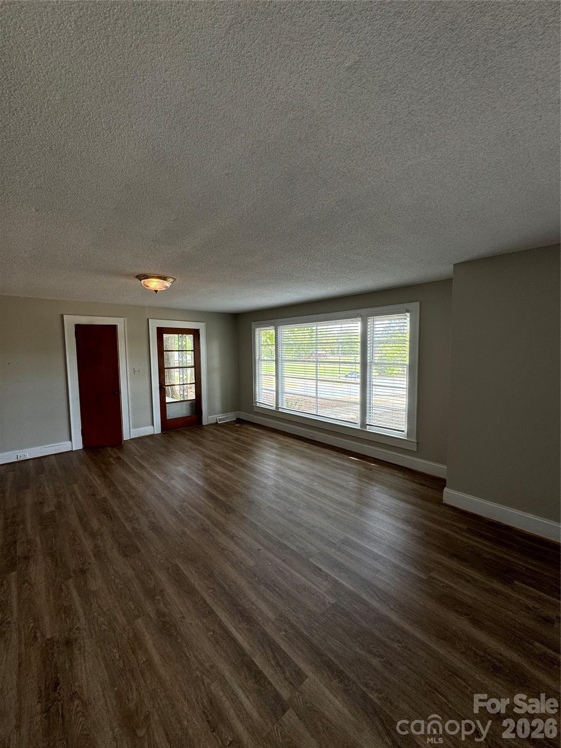 509 East Main Street Locust, NC 28097 - Photo 8 of 40 a view of an empty room with wooden floor and window