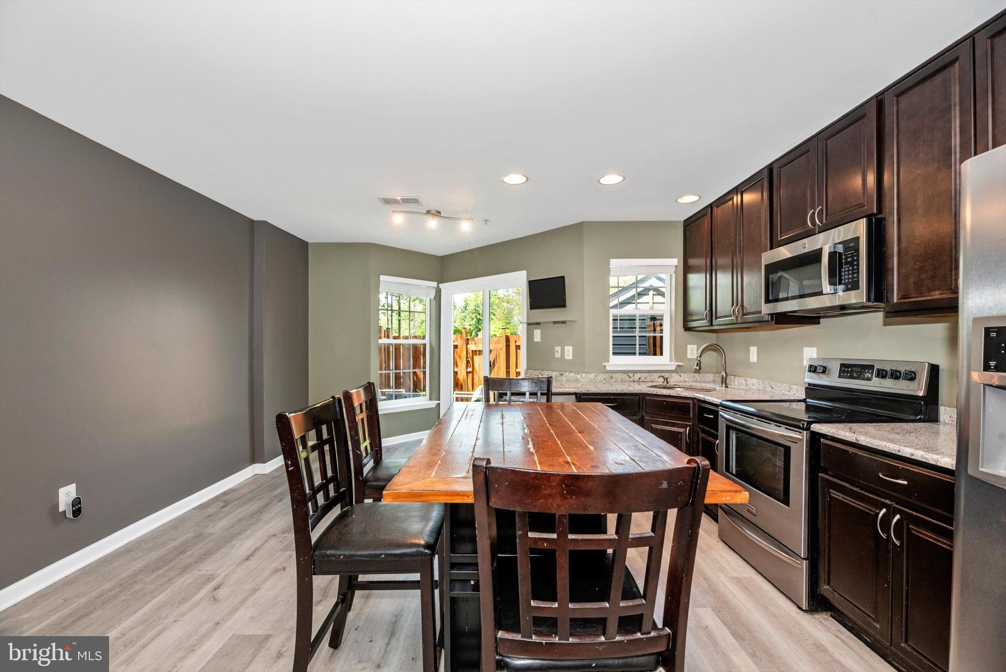 605 Tivoli Road Frederick, MD 21703 - Photo 7 of 35 a kitchen with stainless steel appliances granite countertop a stove a refrigerator a kitchen island a table and chairs