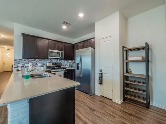 a kitchen with stainless steel appliances a refrigerator sink and microwave