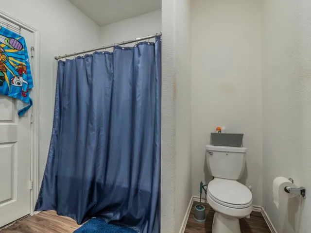 a white toilet sitting next to a wooden cabinet
