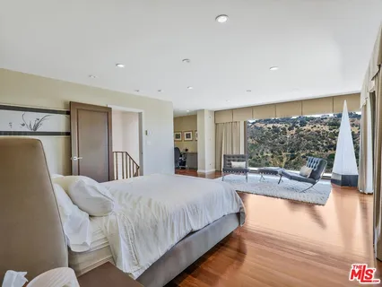 a bedroom with a bed couch and a large window