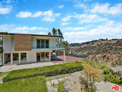 a view of a house with a yard and sitting area