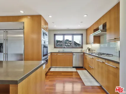 a large kitchen with stainless steel appliances granite countertop a refrigerator and a stove top oven