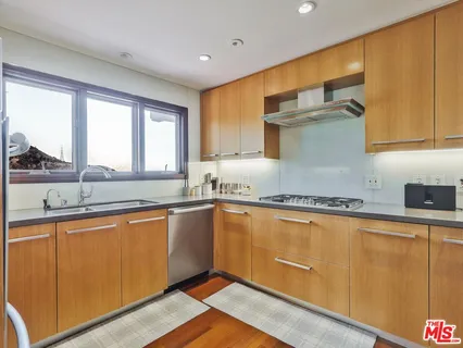 a kitchen with granite countertop wooden cabinets a sink and a window