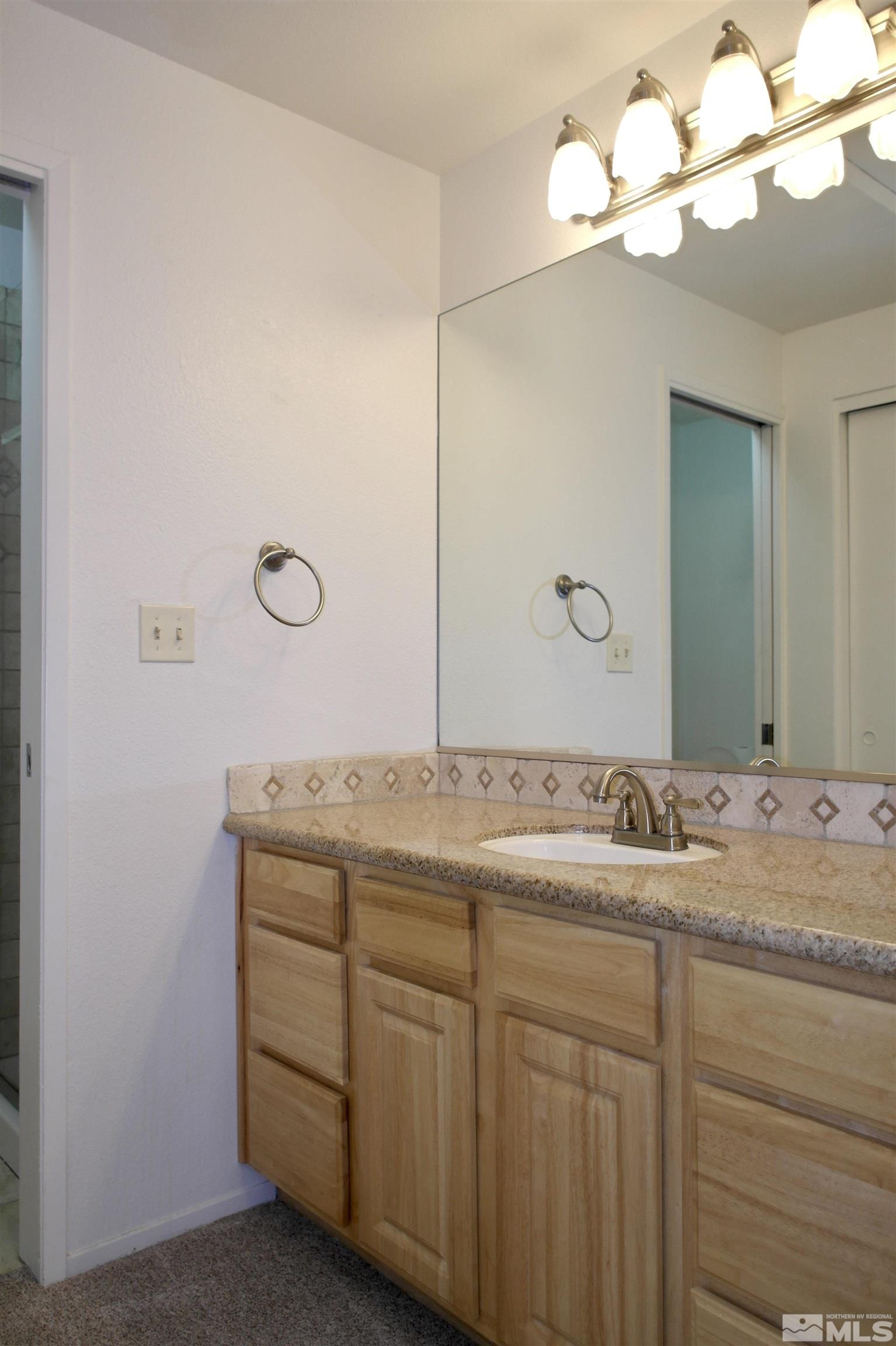 1187 Wagon Wheel Circle Reno, NV 89503 - Photo 15 of 29 a bathroom with a granite countertop sink and a mirror