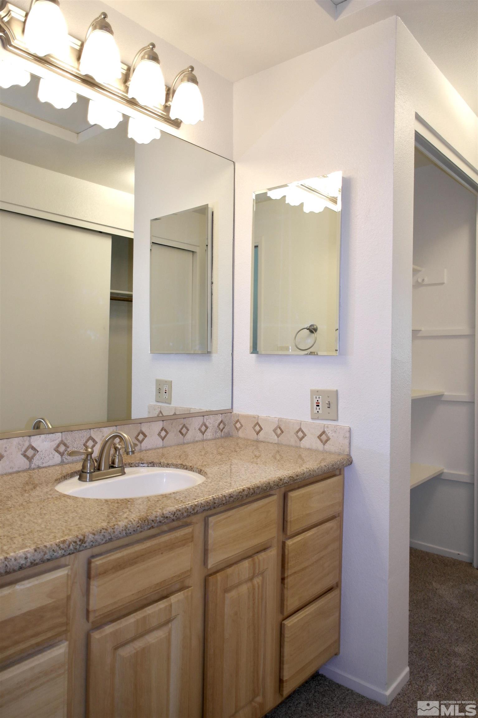 1187 Wagon Wheel Circle Reno, NV 89503 - Photo 17 of 29 a bathroom with a granite countertop sink a large mirror and a shower