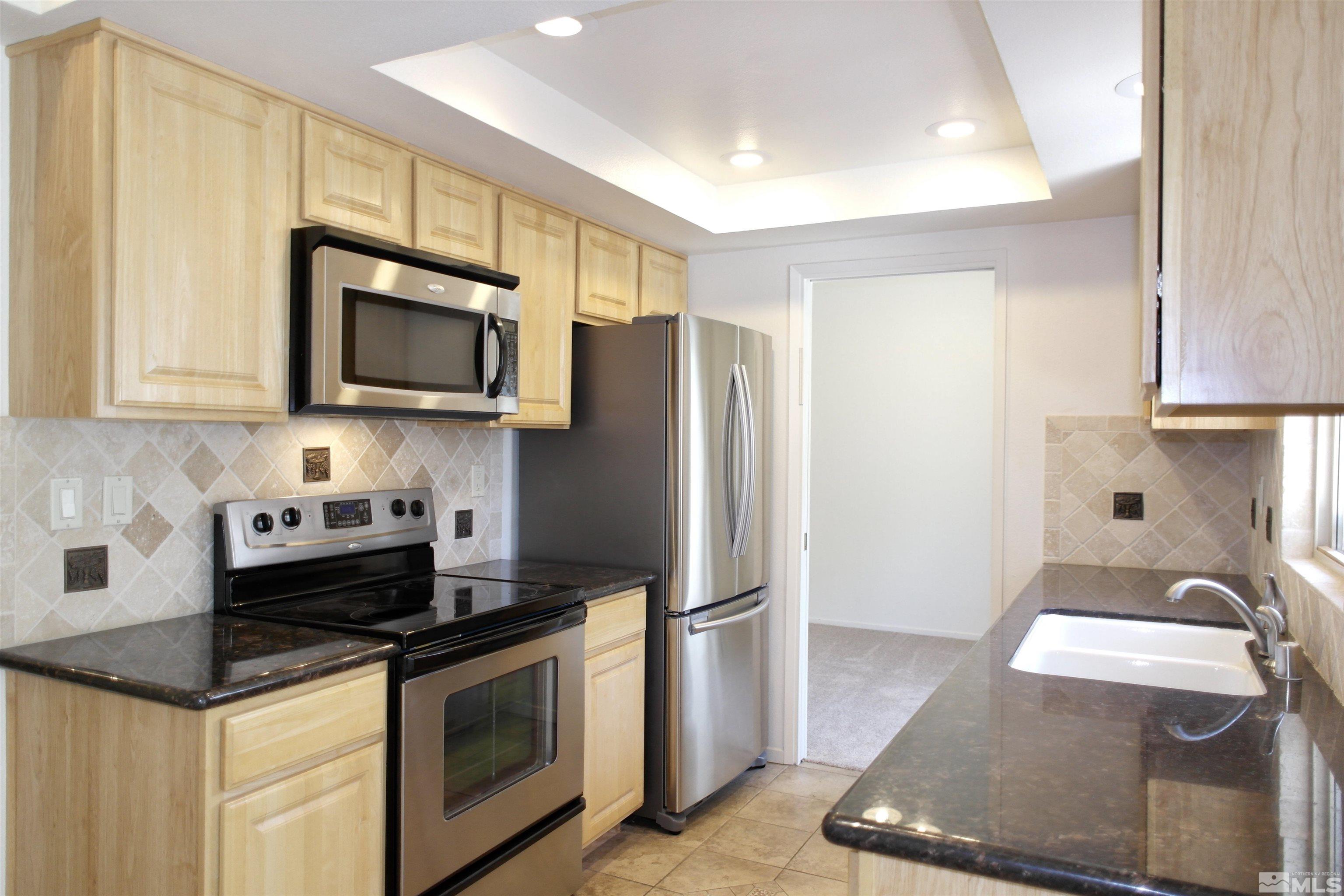 1187 Wagon Wheel Circle Reno, NV 89503 - Photo 4 of 29 a kitchen with granite countertop a sink stove and refrigerator