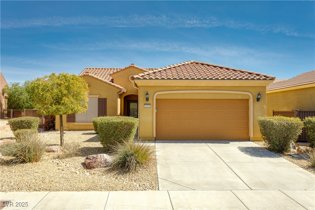 1074 Wagon Trail Mesquite, NV 89034 - Photo 1 of 27 Mediterranean / spanish-style home with driveway, stucco siding, fence, an attached garage, and a tiled roof