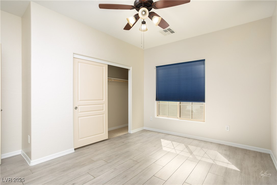 1074 Wagon Trail Mesquite, NV 89034 - Photo 18 of 27 Unfurnished bedroom featuring a closet, visible vents, light wood-style flooring, and baseboards