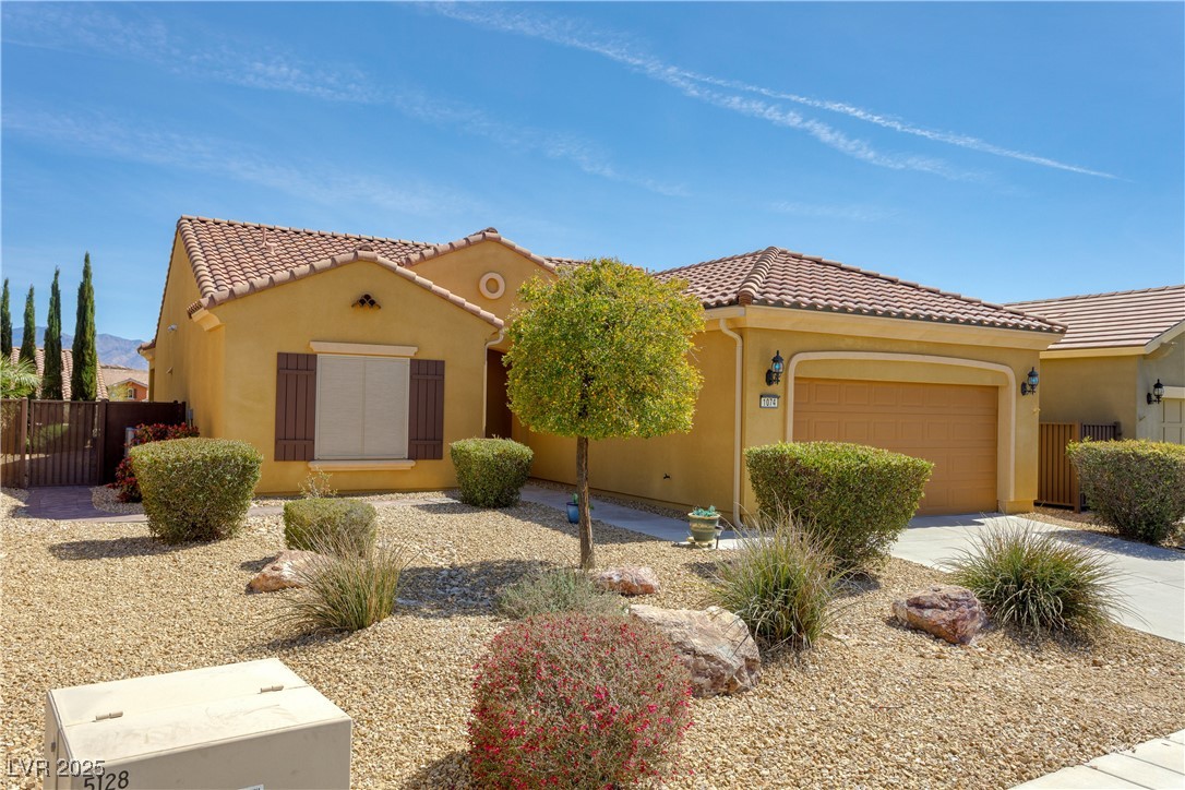 1074 Wagon Trail Mesquite, NV 89034 - Photo 26 of 27 Mediterranean / spanish home featuring a tile roof, driveway, stucco siding, fence, and an attached garage