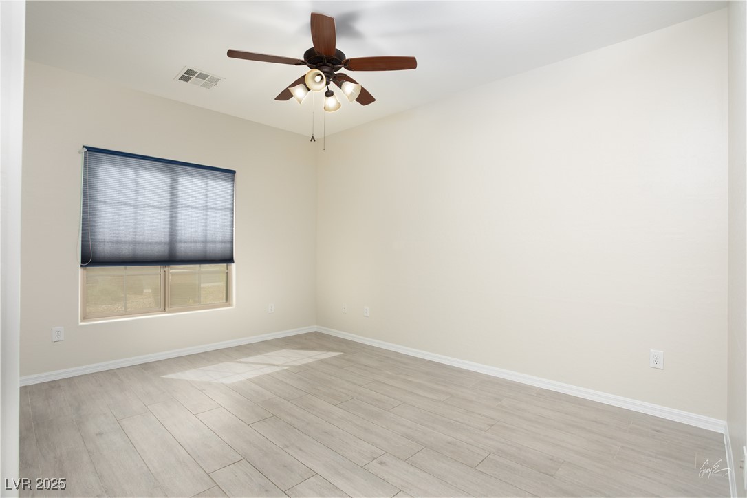 1074 Wagon Trail Mesquite, NV 89034 - Photo 3 of 27 Spare room featuring baseboards, visible vents, a ceiling fan, and light wood-style flooring