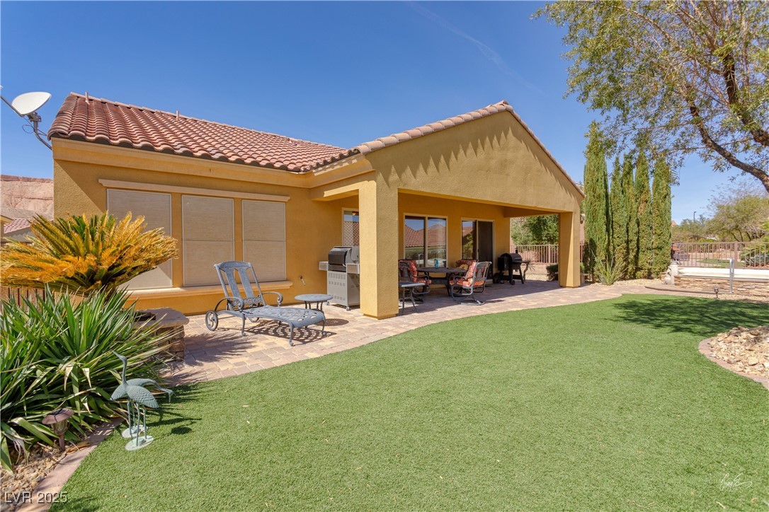 1074 Wagon Trail Mesquite, NV 89034 - Photo 4 of 27 Rear view of house featuring a tile roof, stucco siding, fence, a patio, and a yard