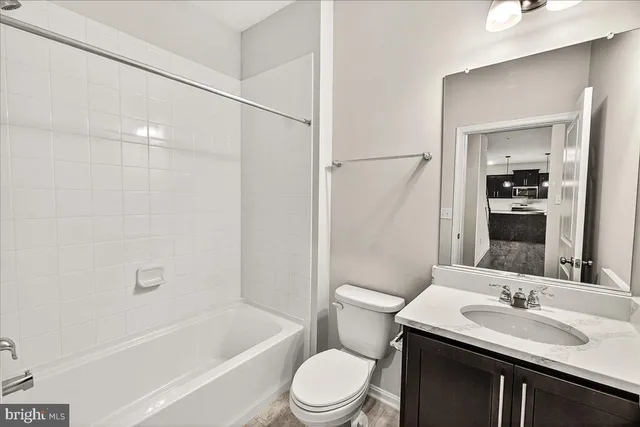 a bathroom with a sink toilet vanity and shower