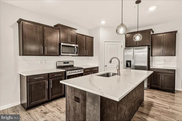 a kitchen with a sink a microwave a stove and refrigerator