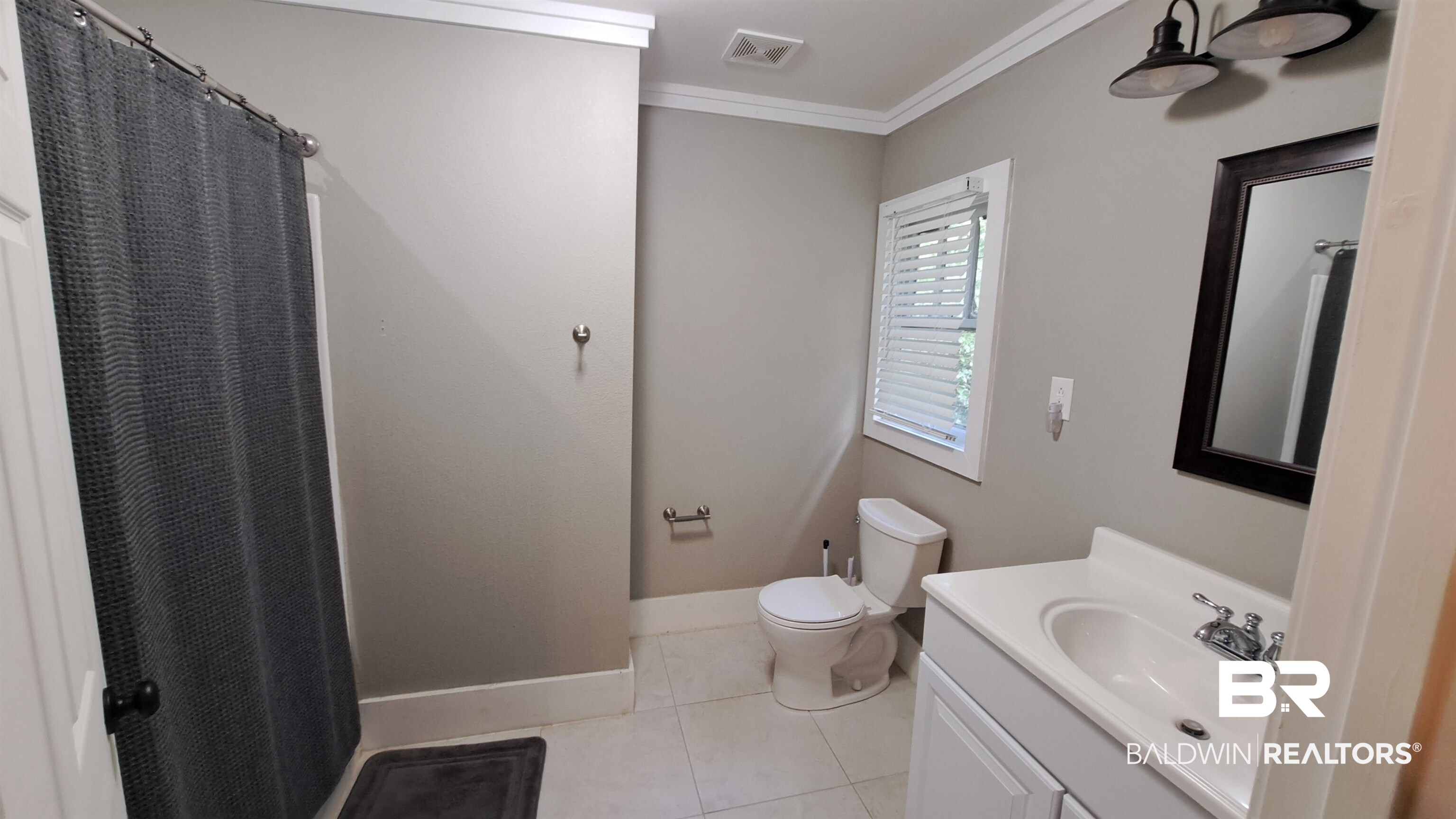 110 South Main Street Evergreen, AL 36401 - Photo 16 of 27 Bathroom featuring a white vanity with an integrated sink, framed mirror, and two-light fixture