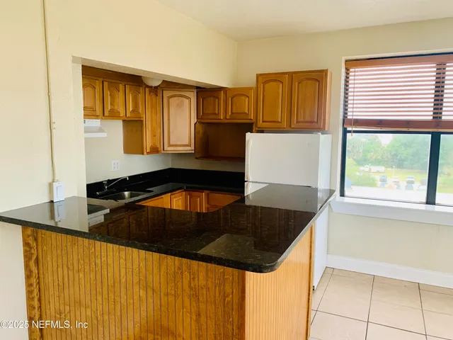 a kitchen with granite countertop white cabinets and black appliances