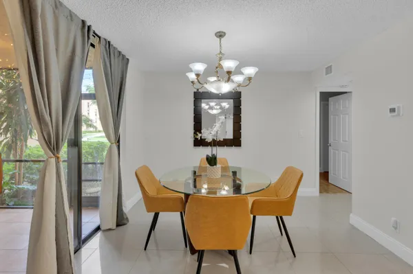 a dining room with furniture a chandelier and window