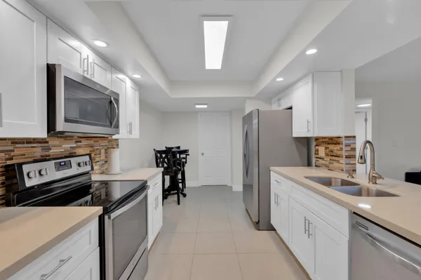 a kitchen with stainless steel appliances a stove sink microwave and cabinets