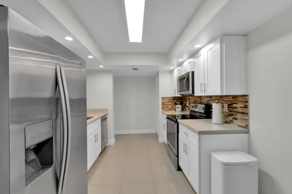 a kitchen with stainless steel appliances a refrigerator a stove top oven a sink and dishwasher