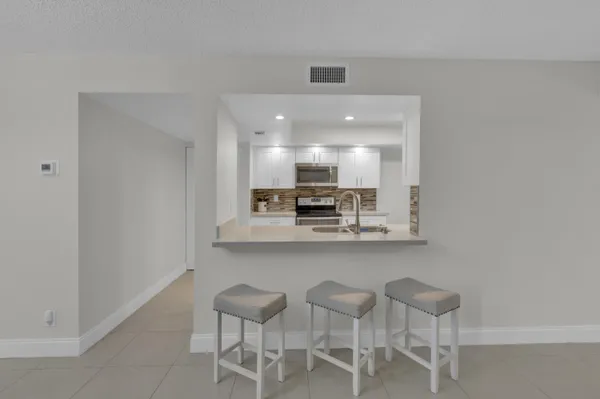 a view of kitchen with granite countertop cabinets table and chairs