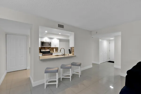 a open kitchen with cabinets and chairs in it
