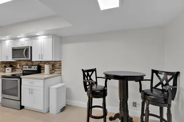 a kitchen with cabinets and chairs