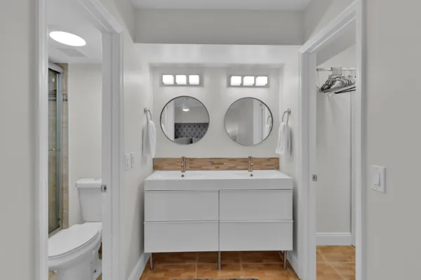 a bathroom with a toilet sink vanity and mirror