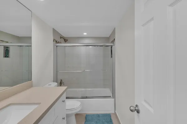a bathroom with a shower a toilet and a sink