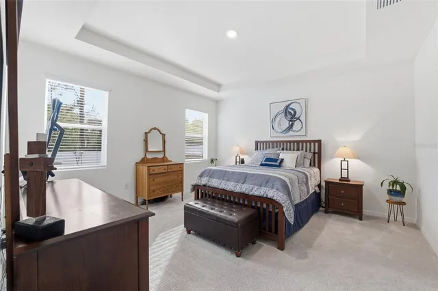 a bedroom with a bed and a dresser next to a window
