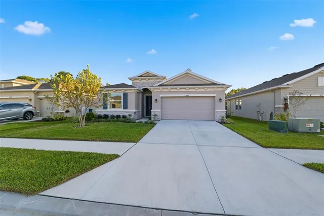 a front view of a house with a yard and garage