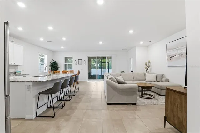 a living room with stainless steel appliances furniture and a flat screen tv