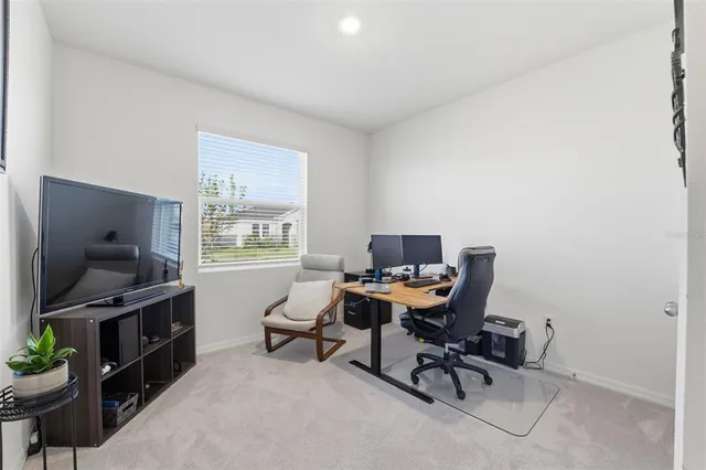 a view of a workspace with furniture and a window
