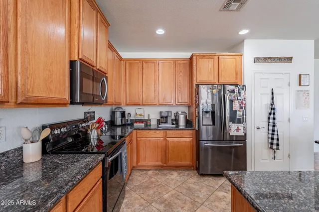 a kitchen with stainless steel appliances granite countertop a refrigerator sink and stove