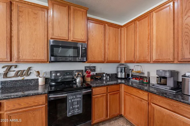 a kitchen with stainless steel appliances granite countertop a sink a stove a microwave and cabinets